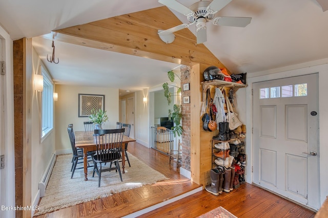 dining room with ceiling fan, vaulted ceiling, wood-type flooring, and a baseboard heating unit