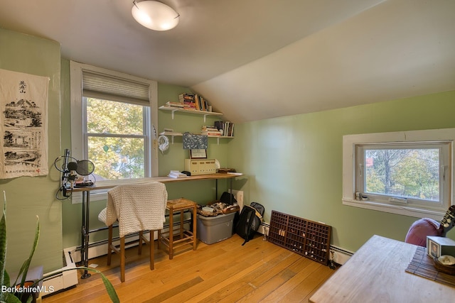 home office featuring lofted ceiling, light wood-type flooring, and a baseboard heating unit