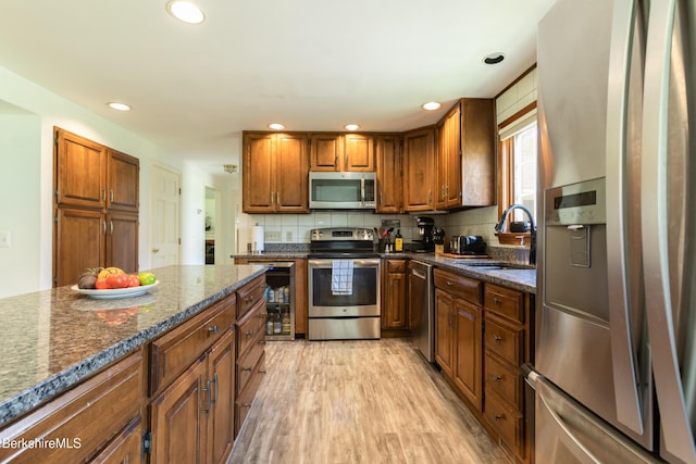 147 Brough Rd, Cheshire, MA 01225 - kitchen with a sink, brown cabinetry, light wood-style flooring, stainless steel appliances, and tasteful backsplash