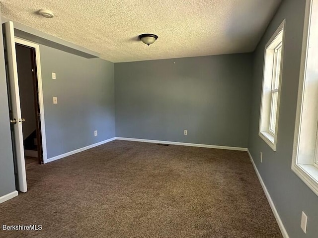 9 Woronoco Rd, Blandford, MA 01008 - unfurnished room with dark colored carpet, a textured ceiling, and a smoke detector