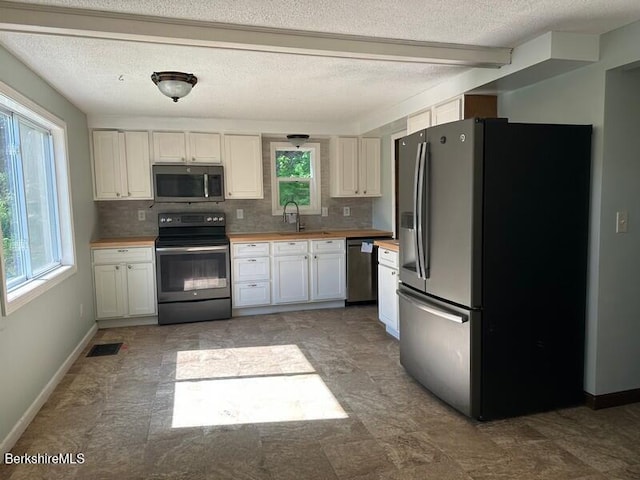 9 Woronoco Rd, Blandford, MA 01008 - kitchen featuring appliances with stainless steel finishes, decorative backsplash, wood counters, white cabinetry, and a textured ceiling