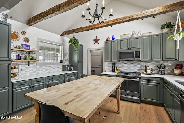 kitchen featuring lofted ceiling with beams, appliances with stainless steel finishes, and decorative backsplash