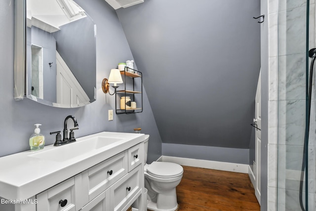 bathroom with toilet, wood finished floors, vanity, baseboards, and vaulted ceiling