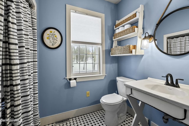 full bathroom featuring toilet, a sink, and baseboards