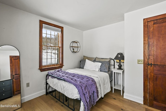 bedroom with baseboards and wood finished floors