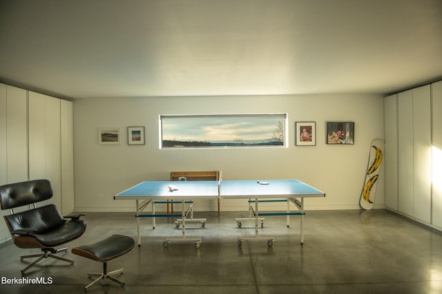 recreation room with finished concrete floors and baseboards