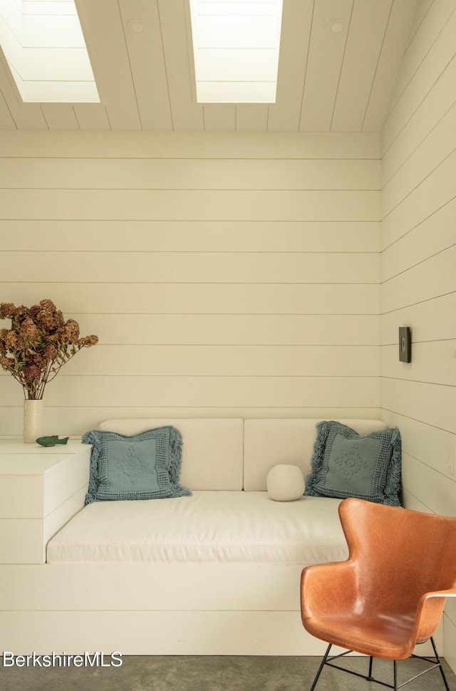 interior space featuring lofted ceiling and wood walls