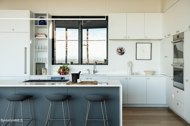 kitchen with light countertops, stainless steel appliances, a sink, and white cabinets