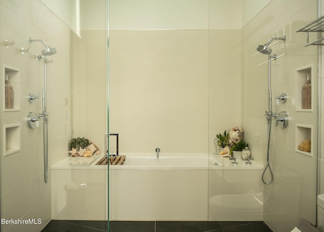 bathroom featuring a garden tub and tiled shower