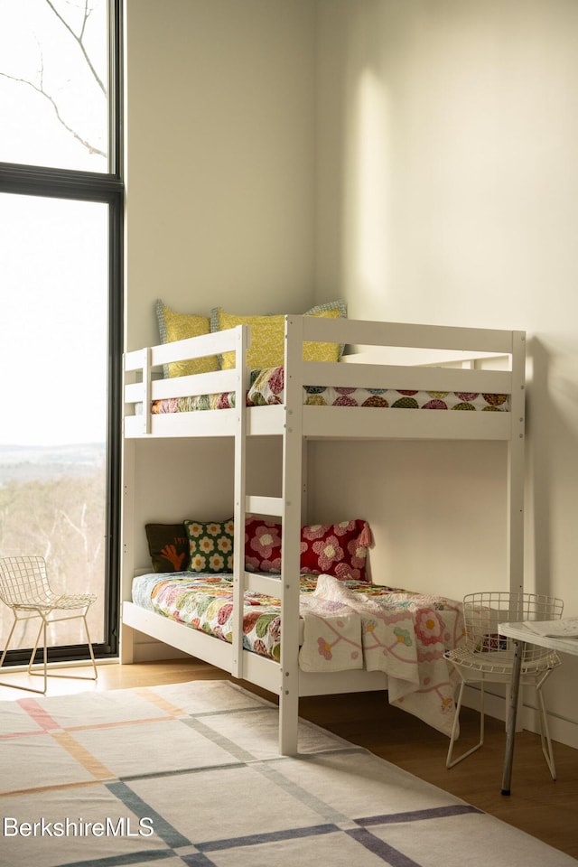 unfurnished bedroom featuring expansive windows and wood finished floors