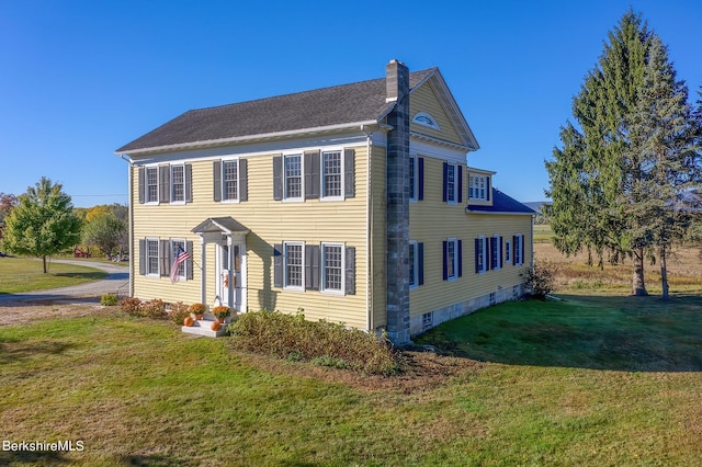 colonial-style house featuring a front yard