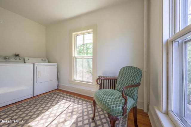 washroom with plenty of natural light, laundry area, wood finished floors, and washer and dryer