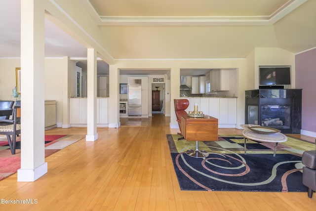 living area featuring ornamental molding, a multi sided fireplace, and hardwood / wood-style floors