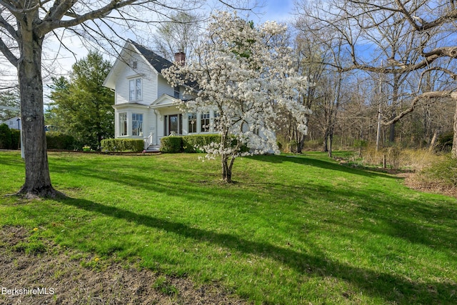 exterior space with a chimney and a front lawn