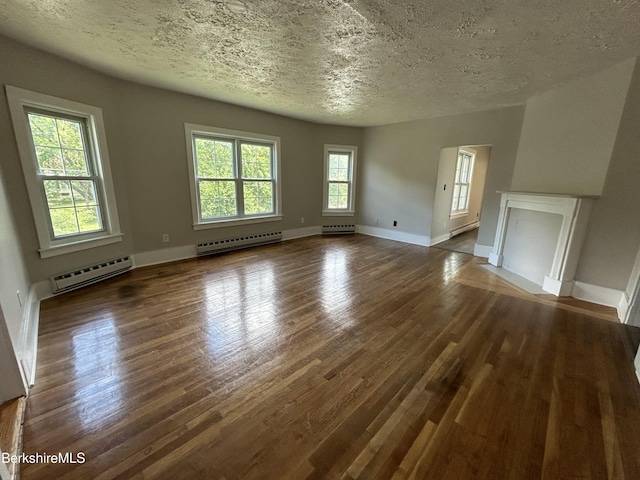 unfurnished living room with dark wood-style flooring, baseboards, a textured ceiling, and baseboard heating