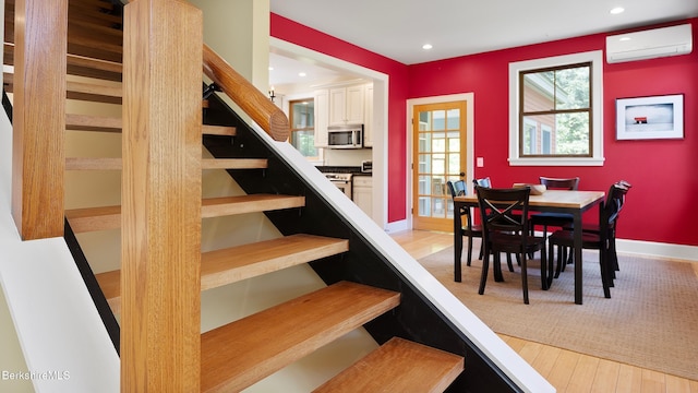11 Jamie Ln, Sandisfield, MA 01255 - dining space featuring an AC wall unit, recessed lighting, stairs, light wood finished floors, and baseboards