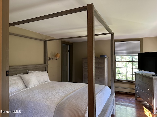 bedroom with baseboard heating and dark hardwood / wood-style flooring