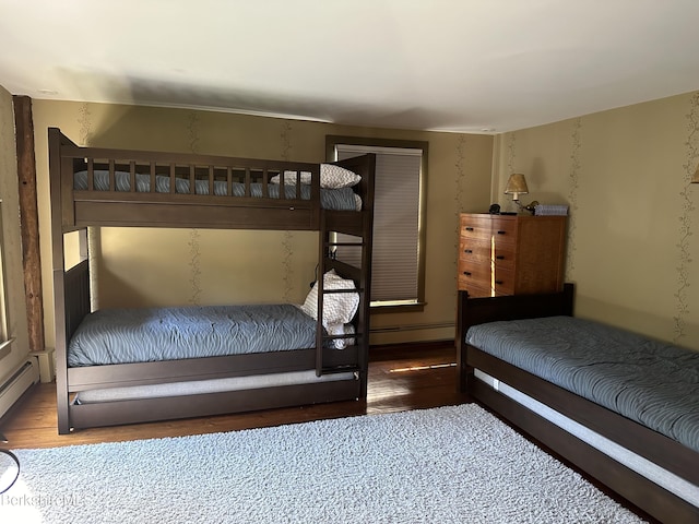 bedroom with baseboard heating and dark wood-type flooring