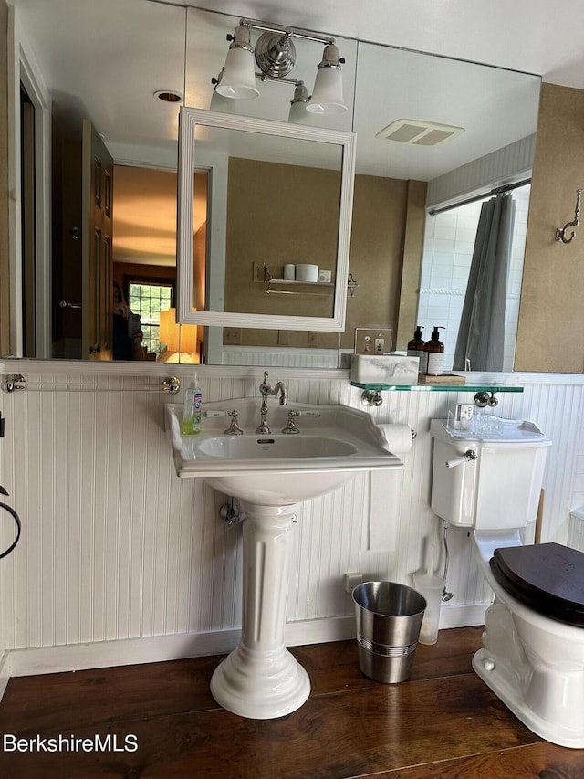 bathroom with hardwood / wood-style floors and toilet