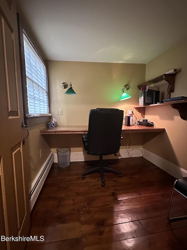 office space with built in desk, baseboard heating, and dark wood-type flooring