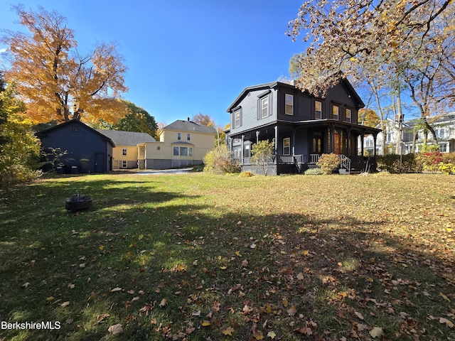 rear view of house featuring a porch and a yard