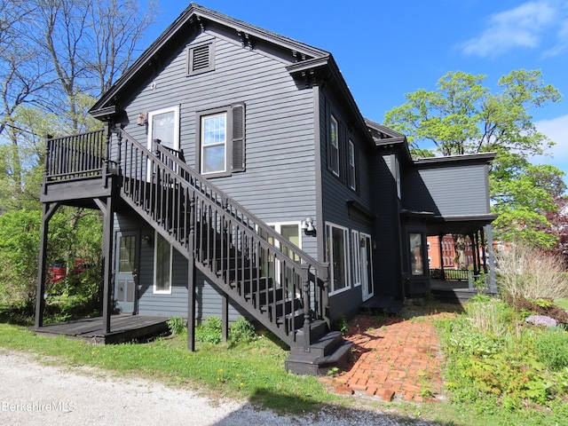 view of side of home featuring stairs, a deck, and a patio area