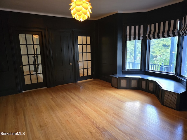 spare room with crown molding and light wood-type flooring