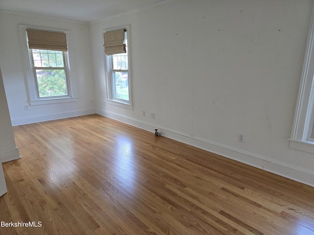 unfurnished room featuring light wood-type flooring and ornamental molding