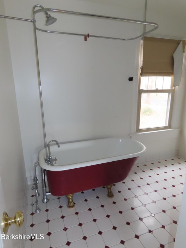 bathroom with a freestanding bath and tile patterned floors