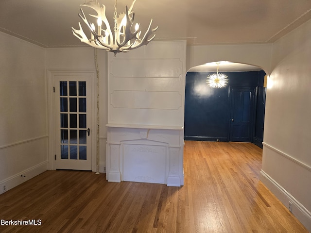 unfurnished dining area with a chandelier and wood-type flooring