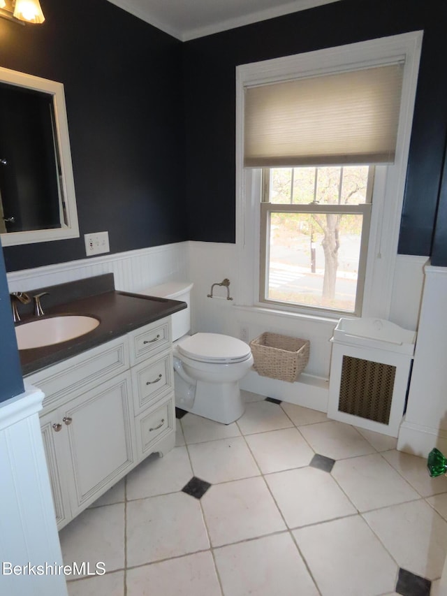 bathroom featuring a wainscoted wall, vanity, toilet, and tile patterned flooring