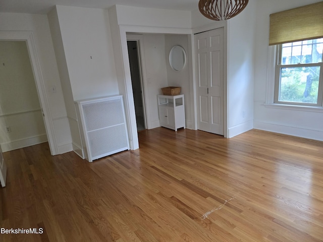 interior space with radiator heating unit and light hardwood / wood-style flooring