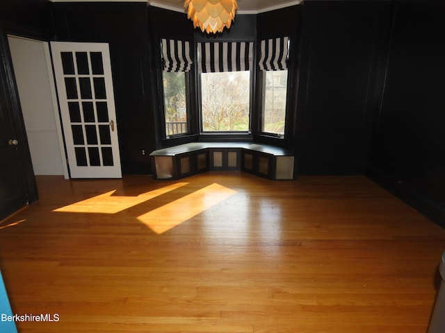 unfurnished dining area with light hardwood / wood-style floors and ornamental molding