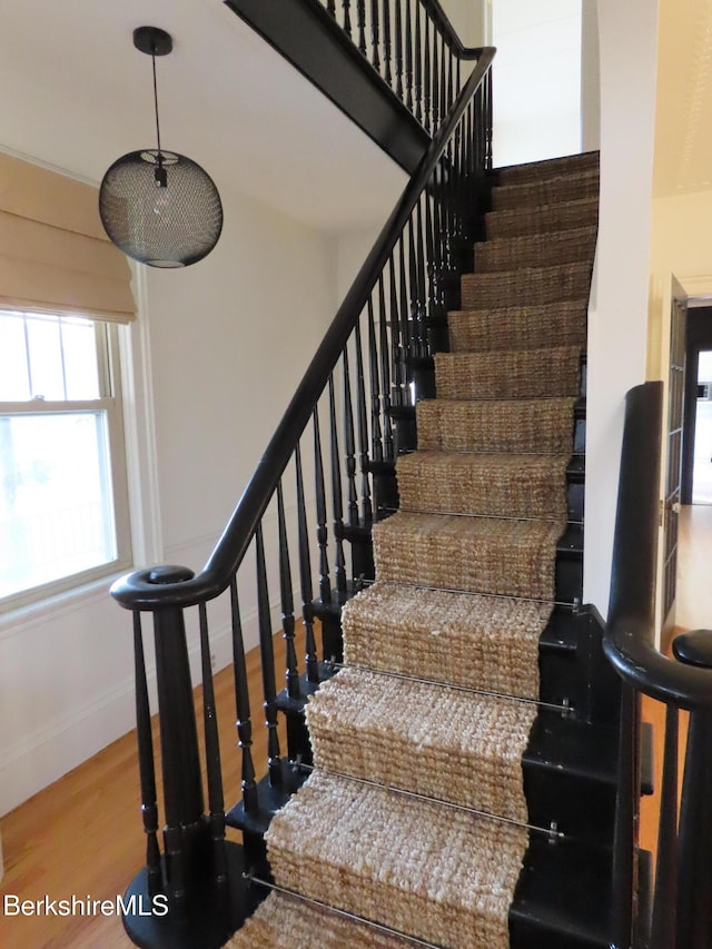 staircase with wood finished floors and baseboards