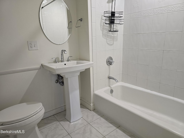 bathroom featuring toilet and tiled shower / bath