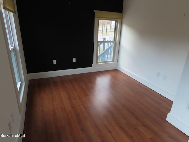 spare room with dark wood-type flooring