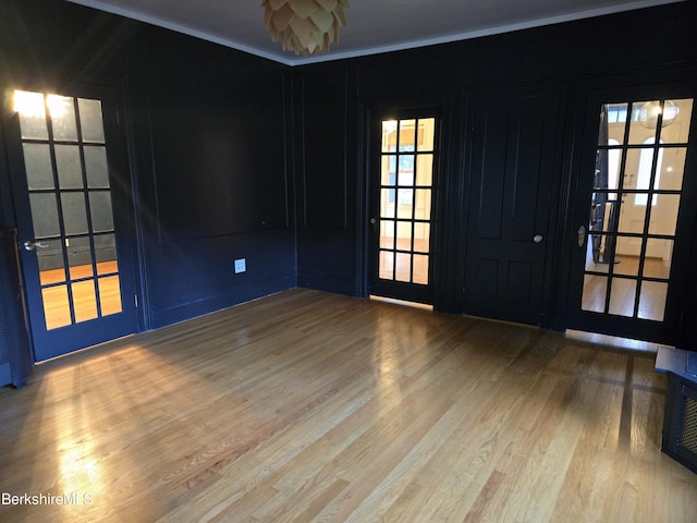 unfurnished room with light hardwood / wood-style floors and french doors