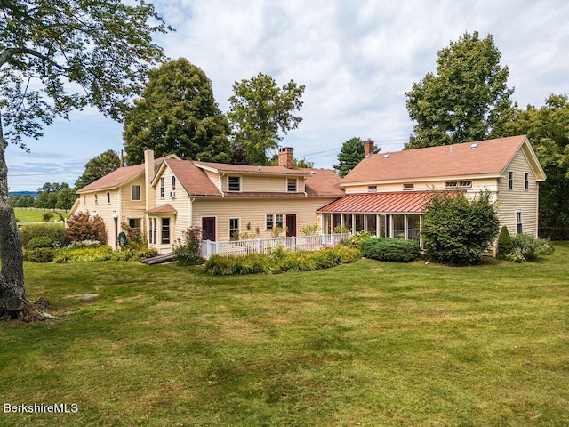 back of house with a sunroom and a yard