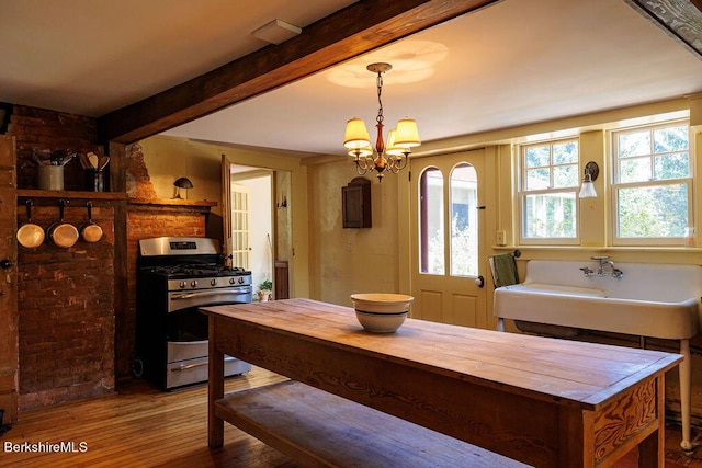 dining area with beamed ceiling, hardwood / wood-style floors, and a notable chandelier