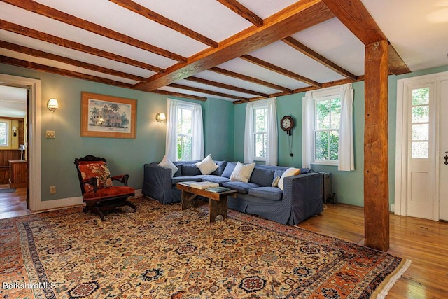 living room featuring beamed ceiling and light wood-type flooring