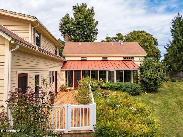 rear view of house with a lawn and a wooden deck