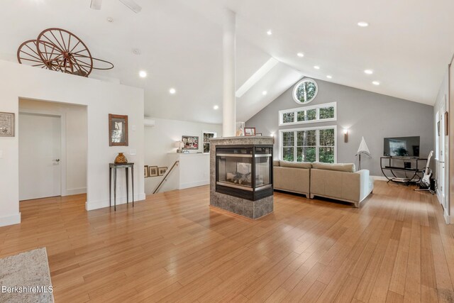 2017 Monterey Rd, Otis, MA 01253 - living room featuring high vaulted ceiling, a multi sided fireplace, light wood-type flooring, and recessed lighting