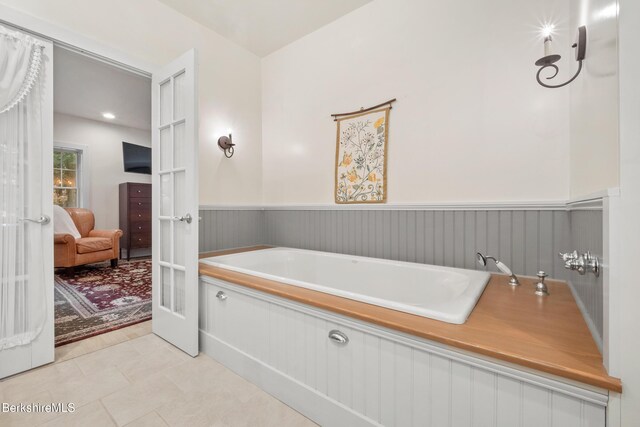 2017 Monterey Rd, Otis, MA 01253 - ensuite bathroom with a garden tub, wainscoting, french doors, and tile patterned flooring