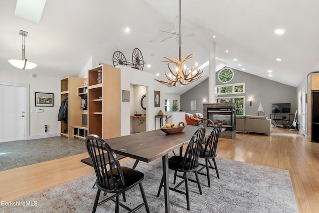 2017 Monterey Rd, Otis, MA 01253 - dining area with light wood finished floors, high vaulted ceiling, a chandelier, a tile fireplace, and recessed lighting