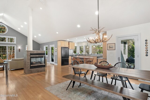2017 Monterey Rd, Otis, MA 01253 - dining room with vaulted ceiling, light wood finished floors, a fireplace, a chandelier, and recessed lighting