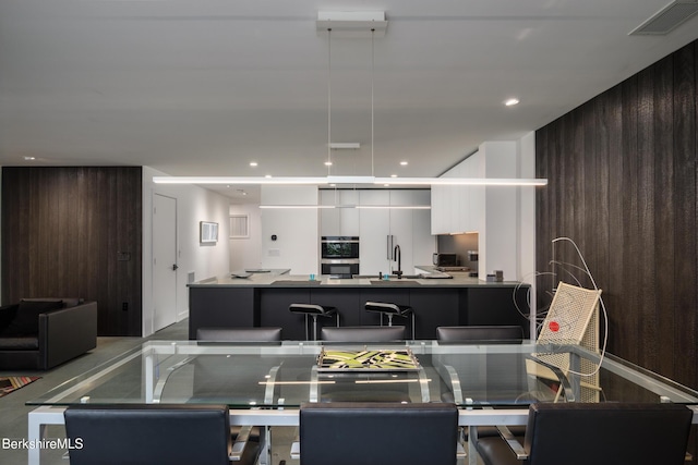 dining area with wood walls and sink