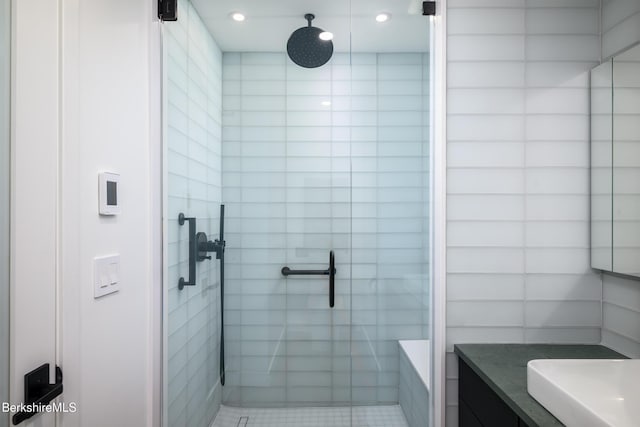 bathroom featuring vanity and a shower with shower door