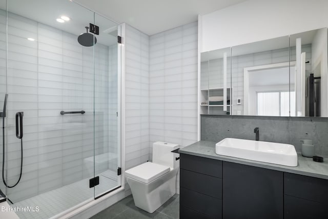 bathroom with vanity, tile patterned flooring, toilet, walk in shower, and tasteful backsplash