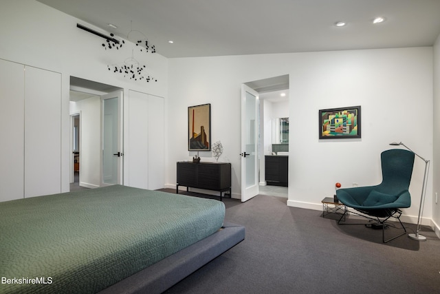 bedroom with connected bathroom, dark carpet, and lofted ceiling