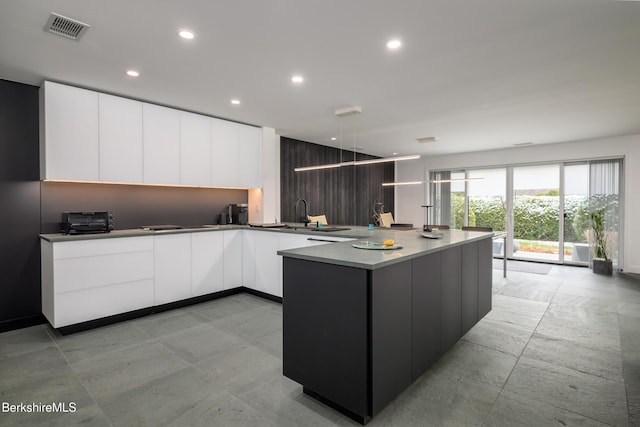 kitchen featuring white cabinetry and sink